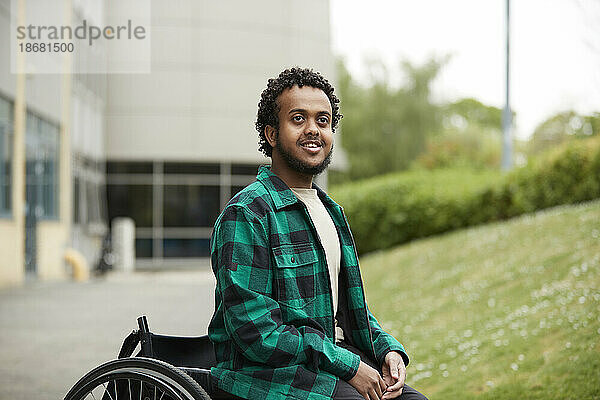 Lächelnder junger Mann im Rollstuhl