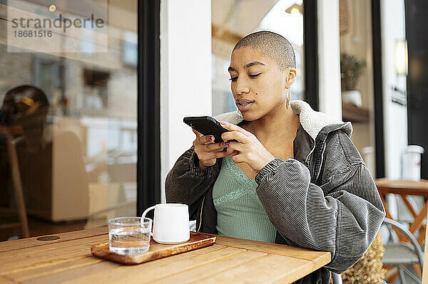 Hipster junge Frau fotografiert Kaffee im Café