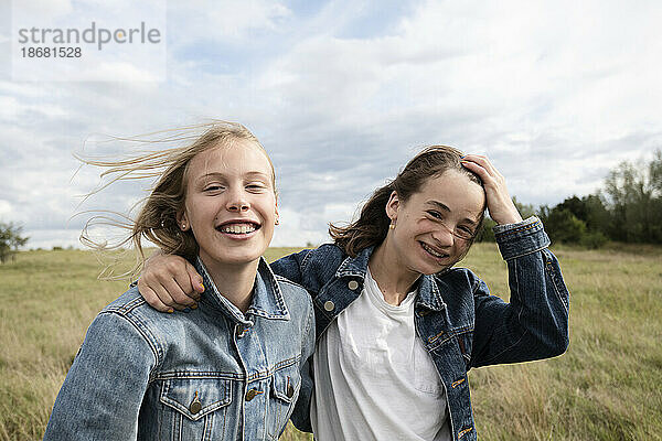 Porträt lächelnder Freundinnen (10-11) im Feld