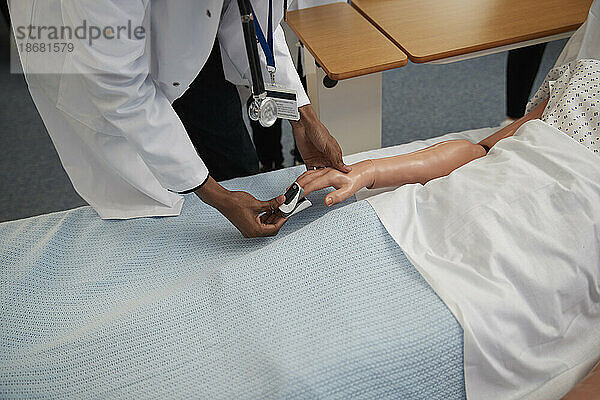 Medizinstudent verwendet Pulsoximeter an einer Puppe