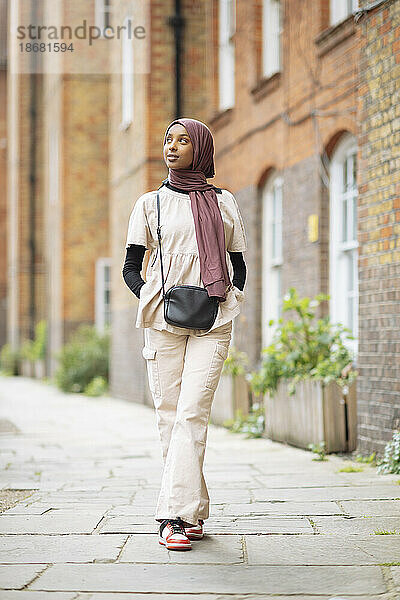 Junge Frau im Hijab steht draußen