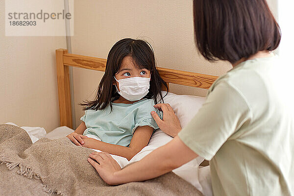 Japanisches Kind liegt krank im Bett