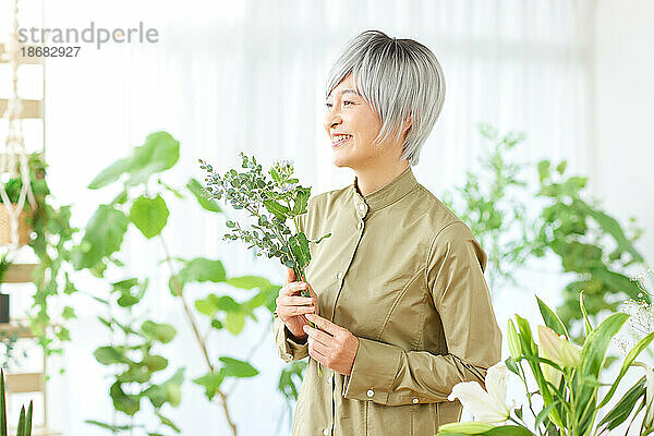 Ältere Japanerin bei der Gartenarbeit