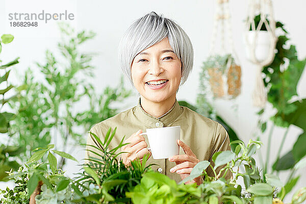 Ältere Japanerin bei der Gartenarbeit