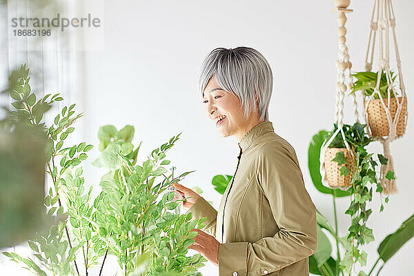 Ältere Japanerin bei der Gartenarbeit