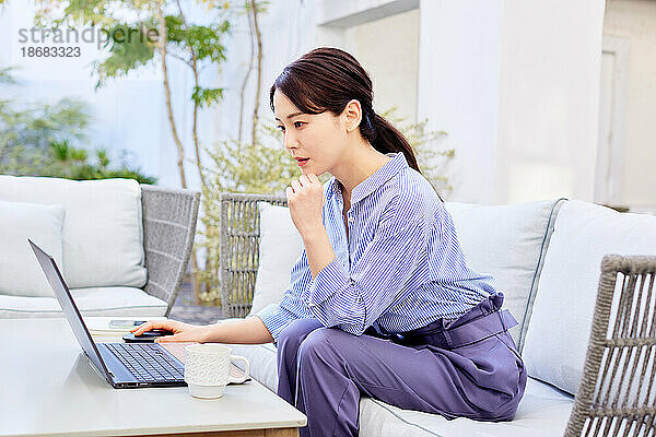 Japanerin arbeitet am Laptop