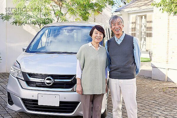 Japanisches älteres Paar mit Auto