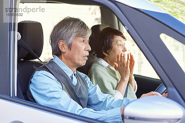 Japanisches älteres Paar mit Auto