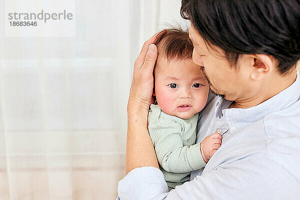 Japanischer Vater und Neugeborenes