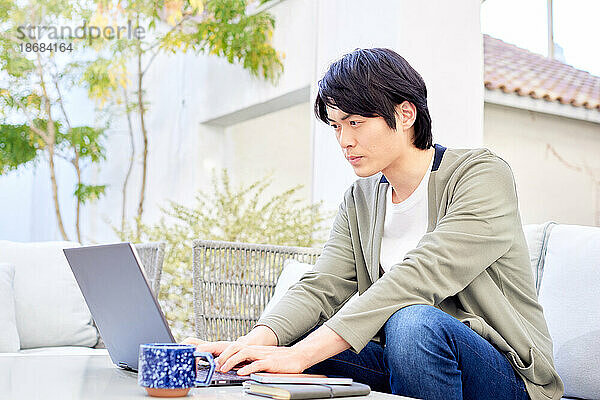 Japaner arbeitet am Laptop
