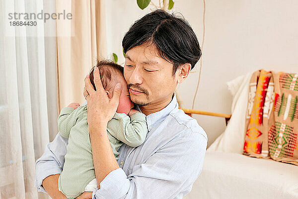 Japanischer Vater und Neugeborenes
