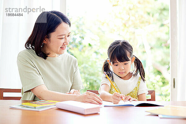 Japanisches Kind lernt mit seiner Mutter