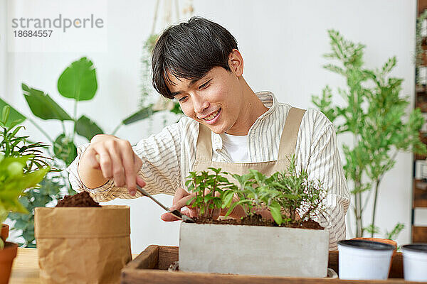 Junger japanischer Mann bei der Gartenarbeit