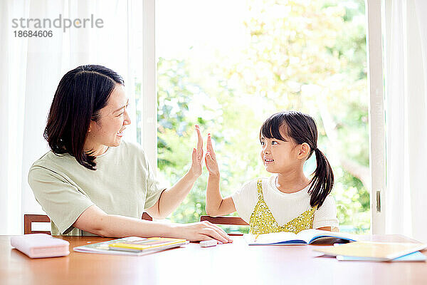 Japanisches Kind lernt mit seiner Mutter
