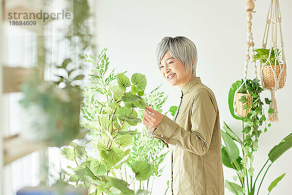 Ältere Japanerin bei der Gartenarbeit