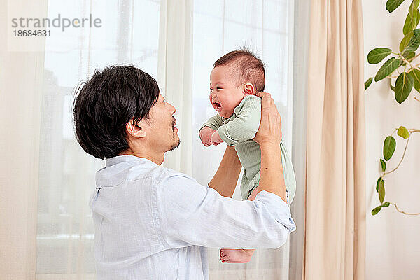 Japanischer Vater und Neugeborenes