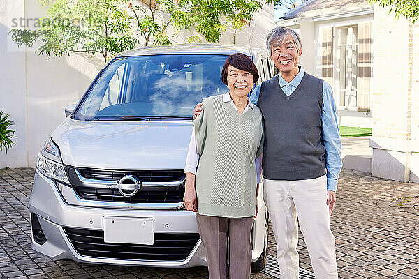 Japanisches älteres Paar mit Auto