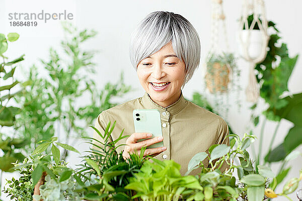 Ältere Japanerin bei der Gartenarbeit