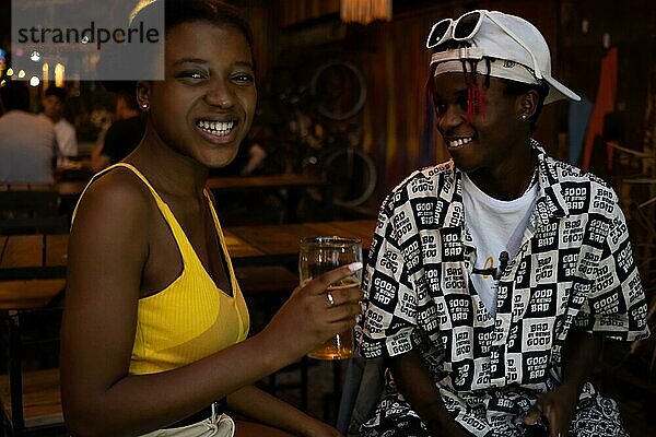 Junges Afro Paar in einem Nachtclub  Freundin schaut in die Kamera und lacht