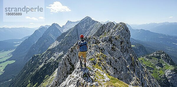 Bergsteiger am Gipfel der Oberen Wettersteinspitze  Blick auf den felsigen Bergkamm des Wettersteingrat  Wettersteingebirge  Bayerische Alpen  Bayern  Deutschland  Europa