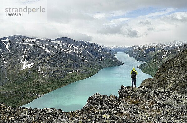 Bergsteiger blickt in die Ferne  Besseggen Wanderung  Gratwanderung  Ausblick auf See Gjende und Berge  Jotunheimen Nationalpark  Vågå  Innlandet  Norwegen  Europa