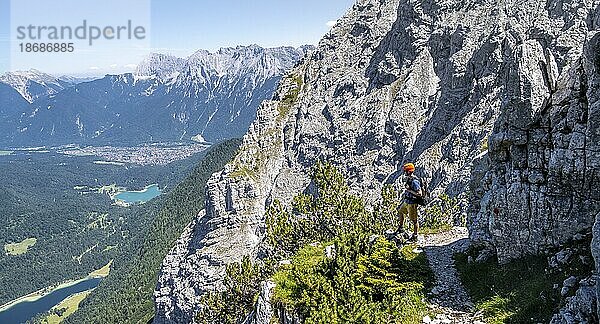 Bergsteiger beim Aufstieg zur Oberen Wettersteinspitze  hinten Lautersee und Karwendelgebirge mit Westlicher Karwendelspitze  Wettersteingebirge  Bayerische Alpen  Bayern  Deutschland  Europa