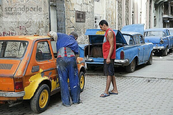 Amerikanische Oldtimer der 1950er Jahre  Ami Panzer und kubanischer Automechaniker reparieren altes Auto auf der Straße in Havanna  Kuba  Karibik  Mittelamerika
