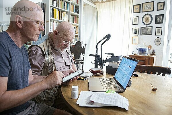 Digitale Welt im Alter. Vater und Sohn mit Handy und Laptop.  Heidelberg  Deutschland  Thema  Europa