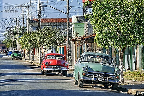 Amerikanische Oldtimer auf der Straße in der Stadt Ranchuelo in der Provinz Villa Clara auf der Insel Kuba  Karibik  geparkt