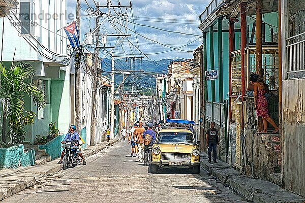 Straßenszene mit bunten Häusern und einem alten amerikanischen Auto in Santiago de Cuba  der Hauptstadt der Provinz Santiago de Cuba auf der Insel Kuba  Karibik