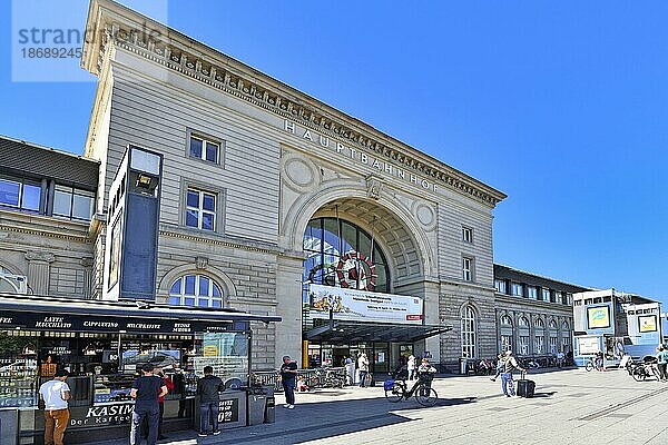 Fassade des Mannheimer Hauptbahnhofs in einem alten historischen Gebäude mit vorbeifahrenden Reisenden  Mannheim  Deutschland  Europa