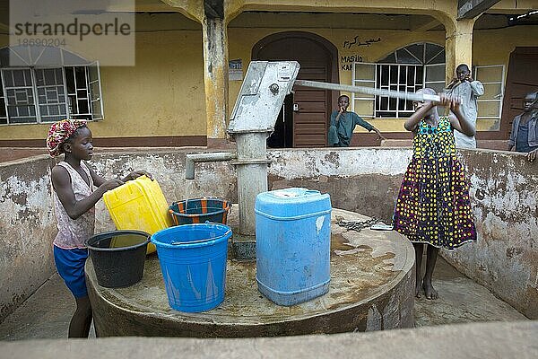 Bomeh Village auf der KissyRoad Müllkippe. Mädchen an der Wasserpumpe  die nur giftiges Wasser liefert  Freetown  15.06.2021. Auf den Müllbergen der Stadt haben die Ärmsten der Armen angefangen zu siedeln. Sie leben über giftigen Dämpfen und mit verdrobenem Wasser.  Sierra Leone  Afrika