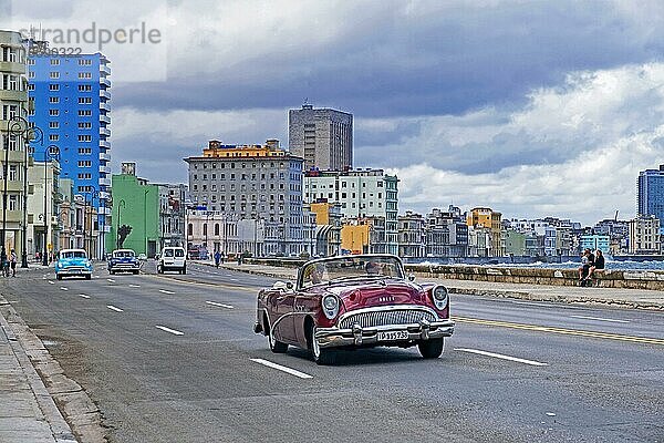 Rotes amerikanisches Oldtimer Auto  Buick aus den 1950er Jahren  privates Taxi auf dem Malecón  Avenida de Maceo  Allee und Uferpromenade entlang der Stadt Havanna auf der Insel Kuba