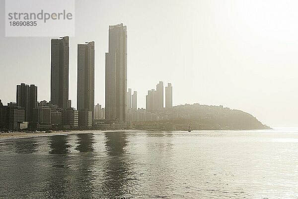 Haeundae Strand  Busan  Südkorea  Stadt am Meer  Leute  Besucher  Morgenlicht  Sonnenaufgang  Wahrzeichen  Statue in Bucht  Silhouette  Asien