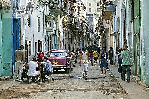 Belebte Straßenszene und rotes altes amerikanisches Auto aus den 1950er Jahren  Yankee Panzer in Alt Havanna  La Habana Vieja  Kuba  Karibik  Mittelamerika