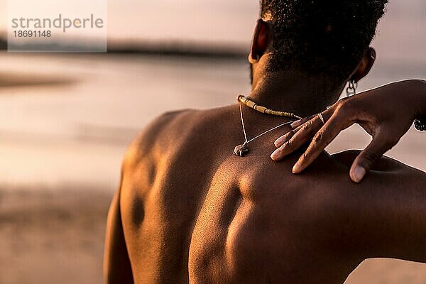 Rücken eines schwarzen ethnischen Mannes im Sommerurlaub am Meer  der sich frei fühlt