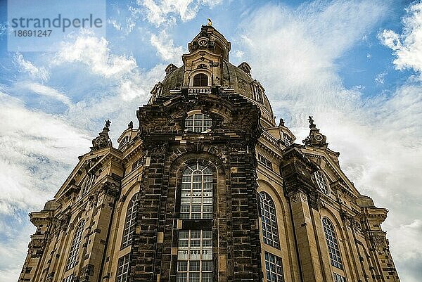 Fassade der Frauenkirche in Dresden  Deutschland  bei Tag  Aufwärtsaufnahme mit großem Himmel. Die im Zweiten Weltkrieg stark zerstörte Kirche wurde anschließend restauriert. Ein Meisterwerk der barocken und klassizistischen Architektur bei Tageslicht. Blauer Himmel und Wolken an einem sonnigen Frühlingstag  Europa