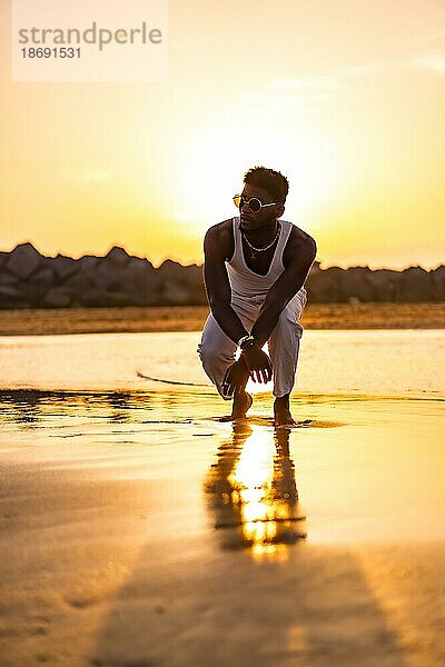 Silhouette von schwarzen ethnischen Modell genießen Sommerurlaub am Meer  mit der Sonne spiegelt sich auf dem Wasser