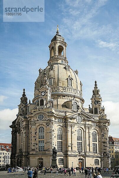 Die im Zweiten Weltkrieg stark zerstörte und anschließend restaurierte Frauenkirche und die Statue Martin Luthers im Zentrum der Altstadt von Dresden  Deutschland. Ein Meisterwerk der barocken und klassizistischen Architektur bei Tageslicht. Blauer Himmel und Wolken an einem sonnigen Frühlingstag