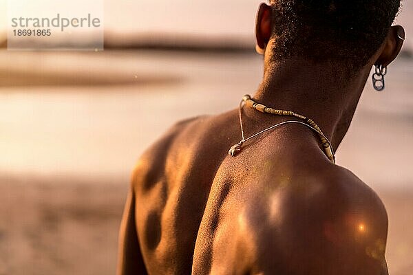 Rücken eines muskulösen schwarzen ethnischen Mannes im Sommerurlaub am Meer  der sich frei fühlt