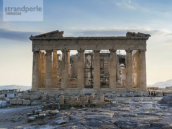 Frontalansicht des Parthenon auf der Akropolis  Athen  Griechenland bei Sonnenuntergang  klarem blauen Himmel und wenigen Touristen  die die Ruinen fotografieren