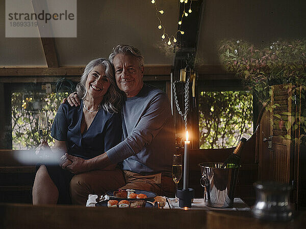 Porträt eines älteren Paares bei einem Candle-Light-Dinner auf einem Boot im Bootshaus