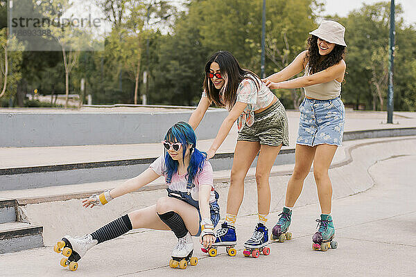 Young friends roller skating together in park