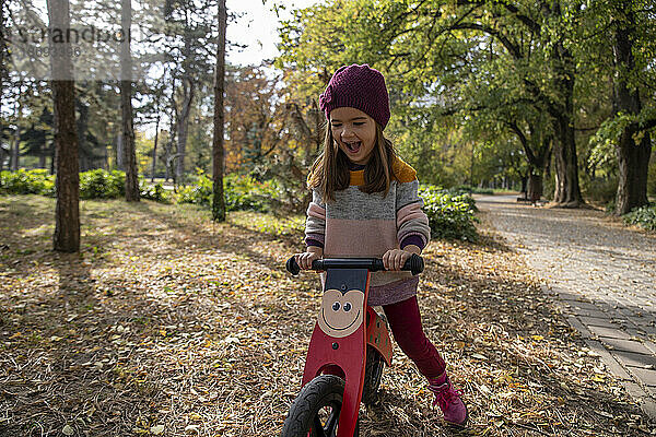 Verspieltes Mädchen fährt Fahrrad im Park