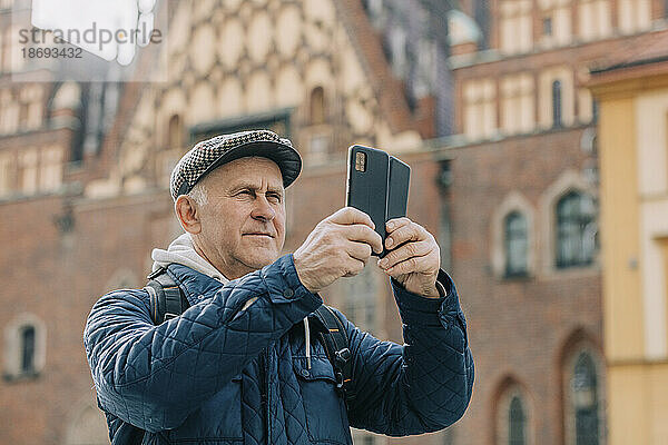 Älterer Mann fotografiert mit Smartphone