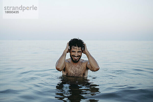 Nackter Oberkörper glücklicher Mann genießt im Meer