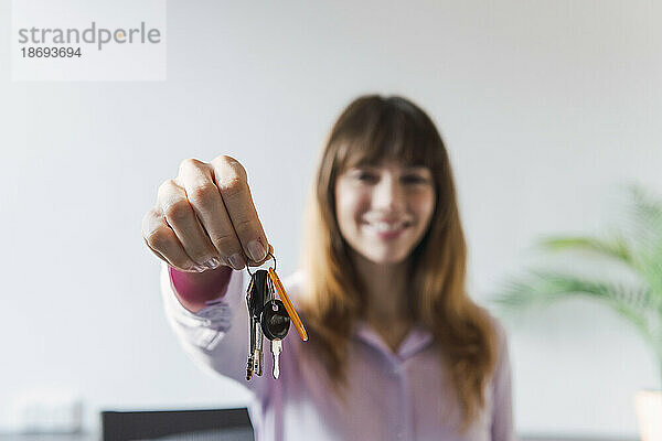 Woman giving house keys in office