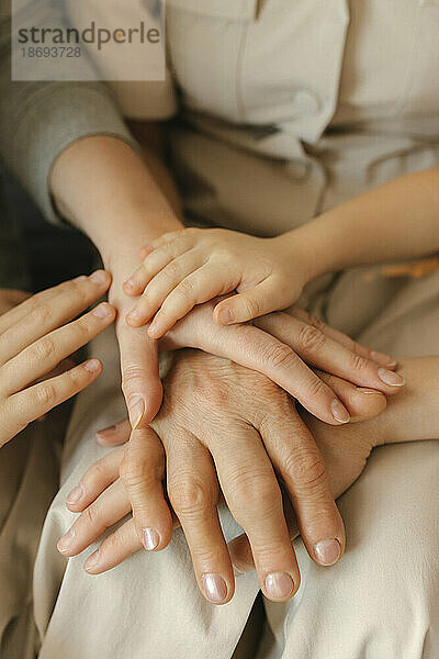 Family stacking hands at home