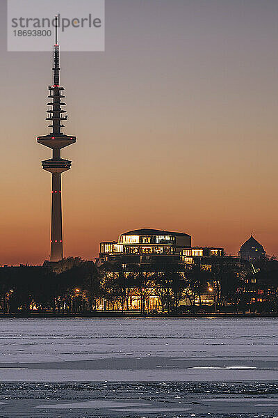 Deutschland  Hamburg  Eis schwimmt in der Abenddämmerung auf der Alster  im Hintergrund der Heinrich-Hertz-Turm