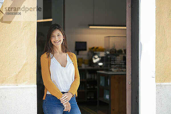 Lächelnder Besitzer steht am Eingang des Cafés